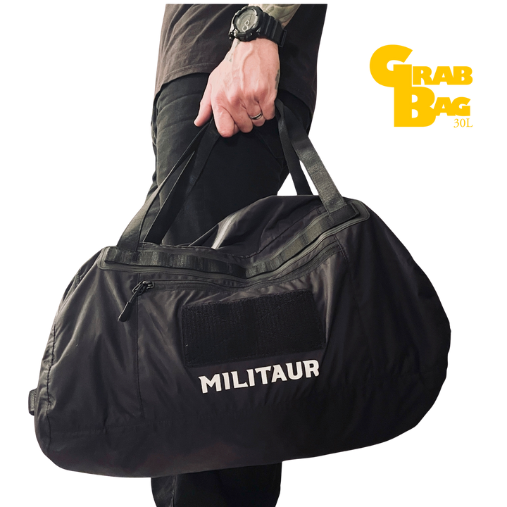 Militaur 30 Liter grab bag go bag in black being held and carried