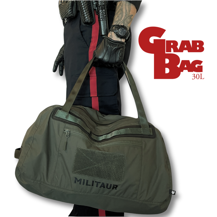 militaur 30l grab bag in forest night green held by a police officer